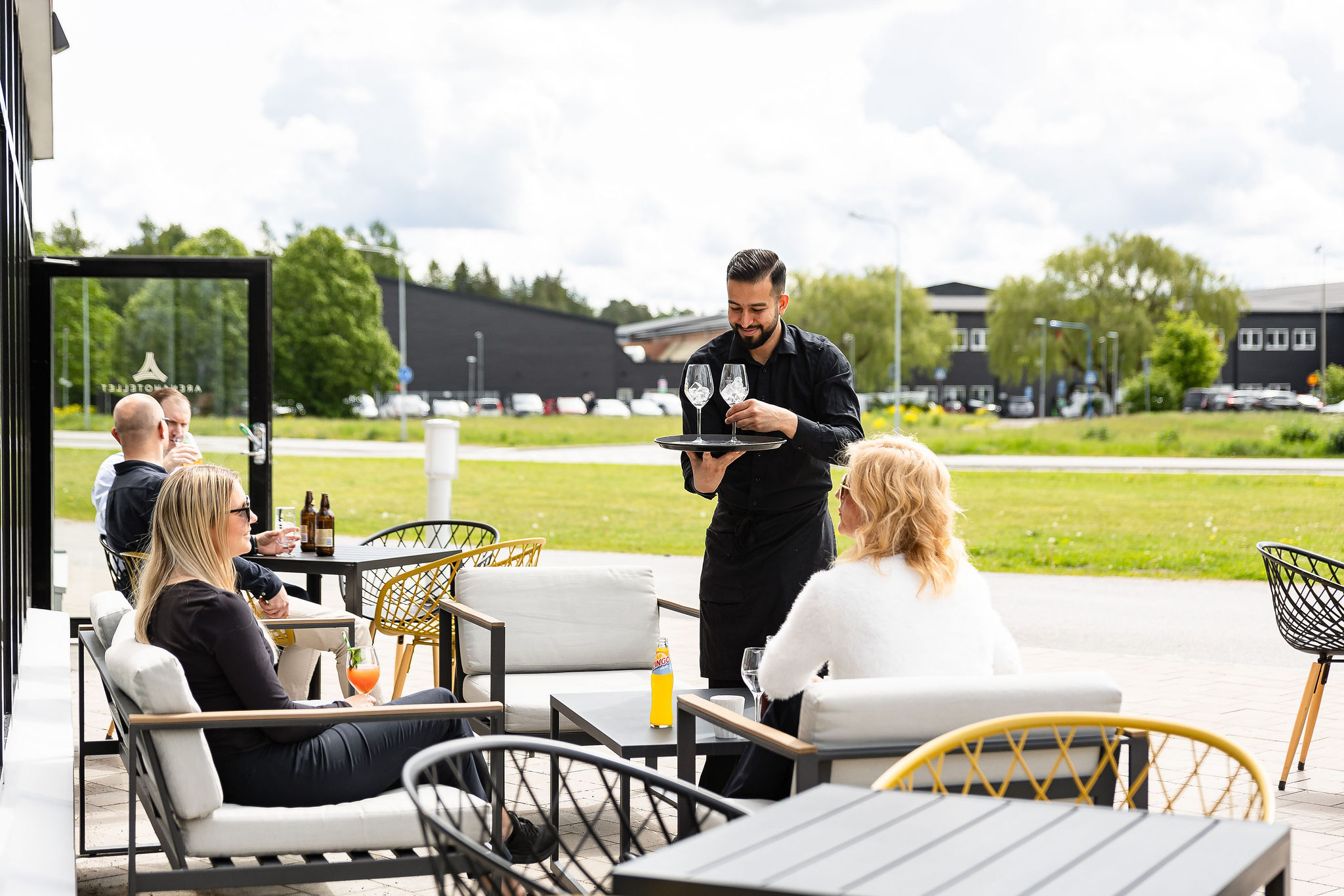 Två kvinnor på uteserveringen som blir serverade varsitt glas