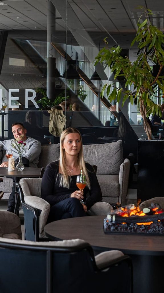 En kvinna i hotellets lounge med en drink i handen