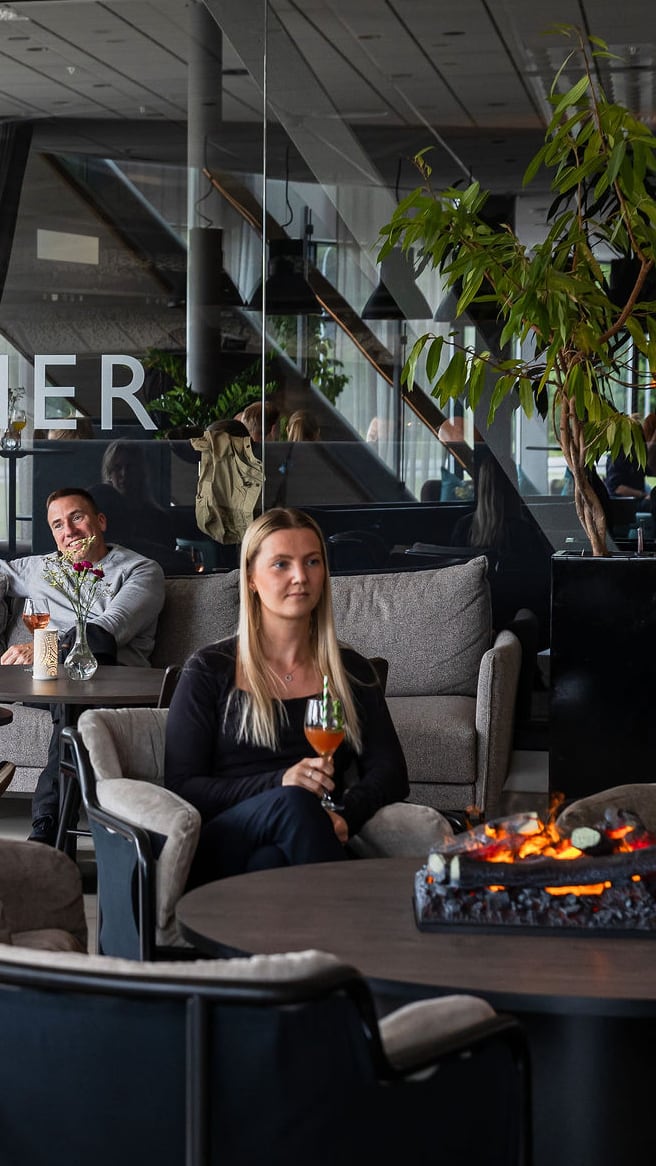 En kvinna i hotellets lounge med en drink i handen