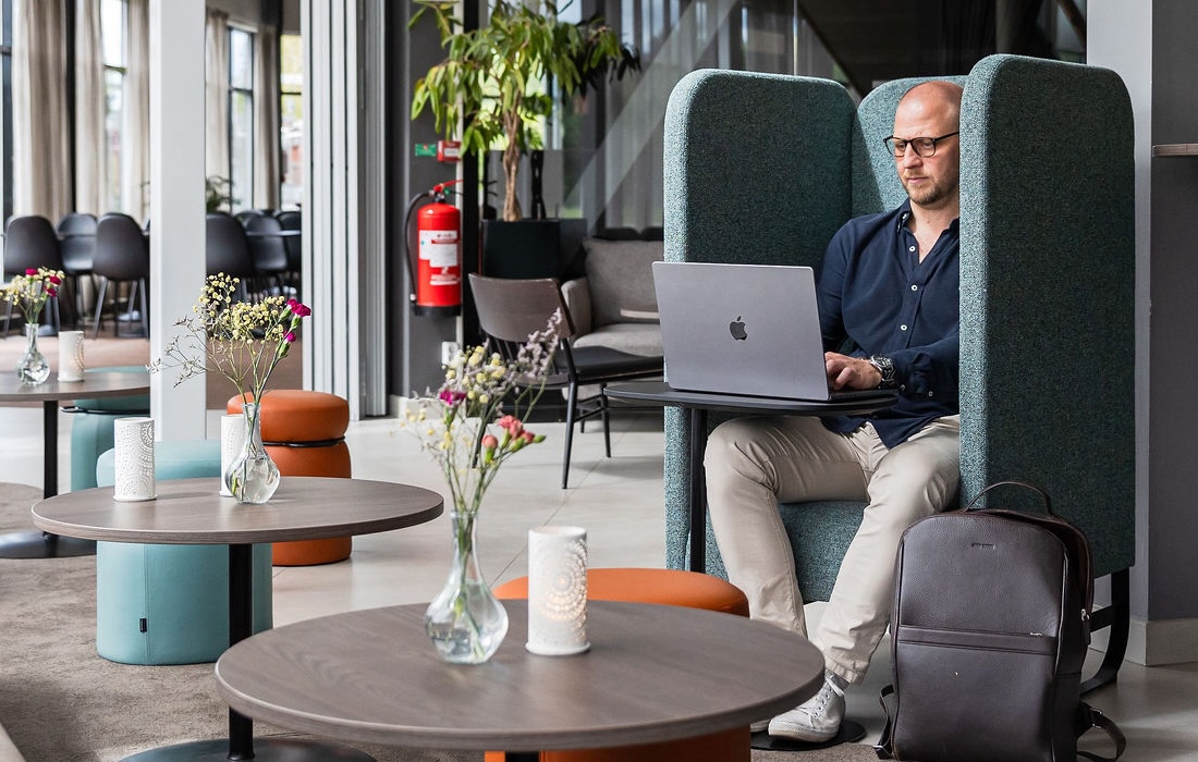 Man som arbetar vid sin dator i Arenahotellets lounge
