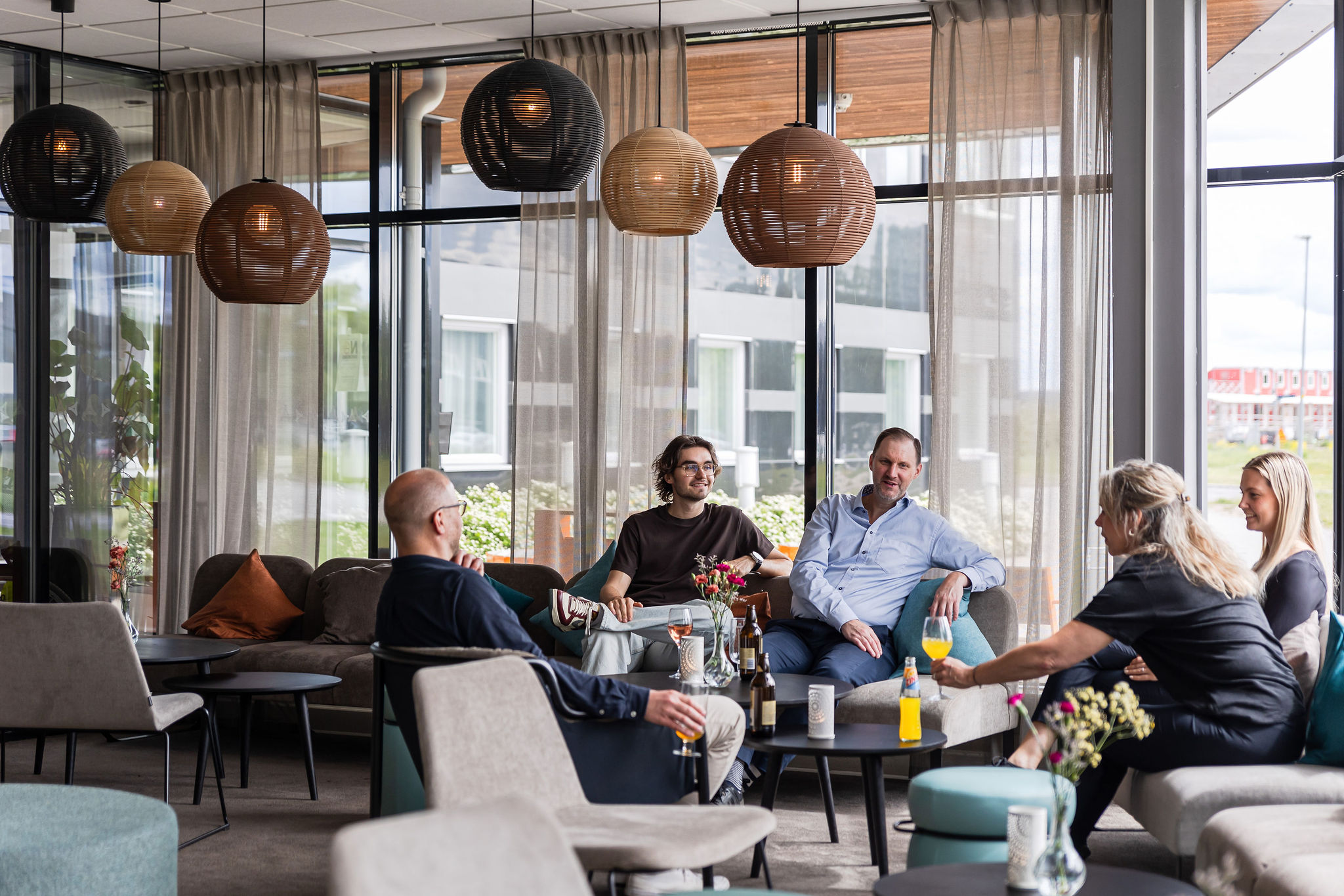 En grupp som sitter i hotellets lounge och pratar och dricker