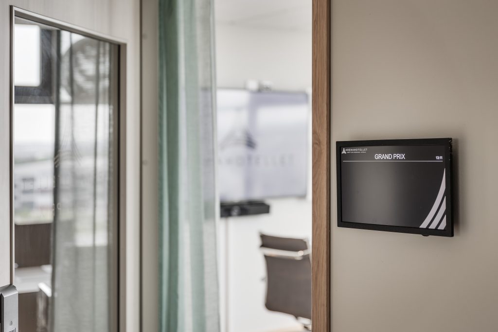 En skärm utanför ett konferensrum som visar namnet på rummet - Grand Prix