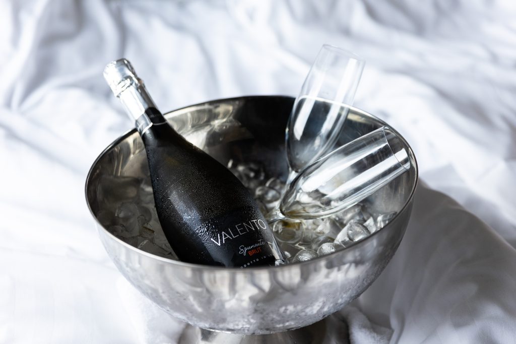 Bottle cooler with ice, a bottle and two glasses in it