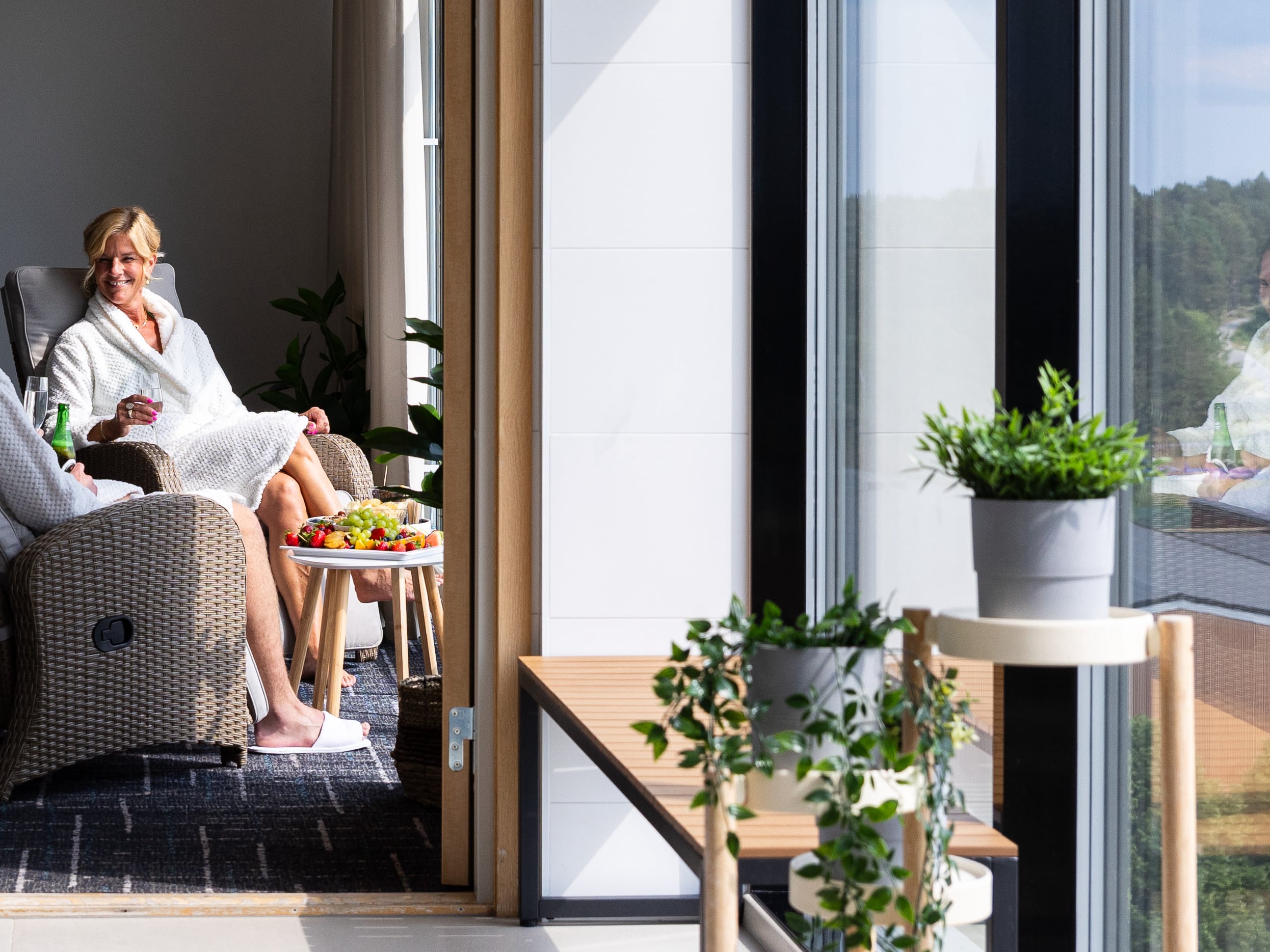 Two visitors in bathrobes sitting in the relaxation area overlooking Uppsala