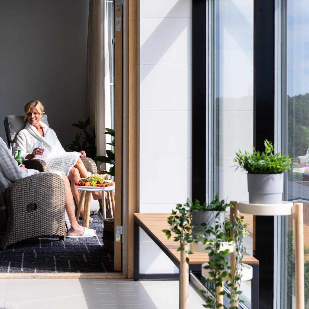 Two visitors in bathrobes sitting in the relaxation area overlooking Uppsala