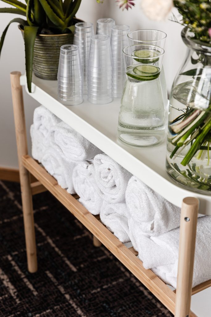 A bench in the relaxation area with towels and water carafes