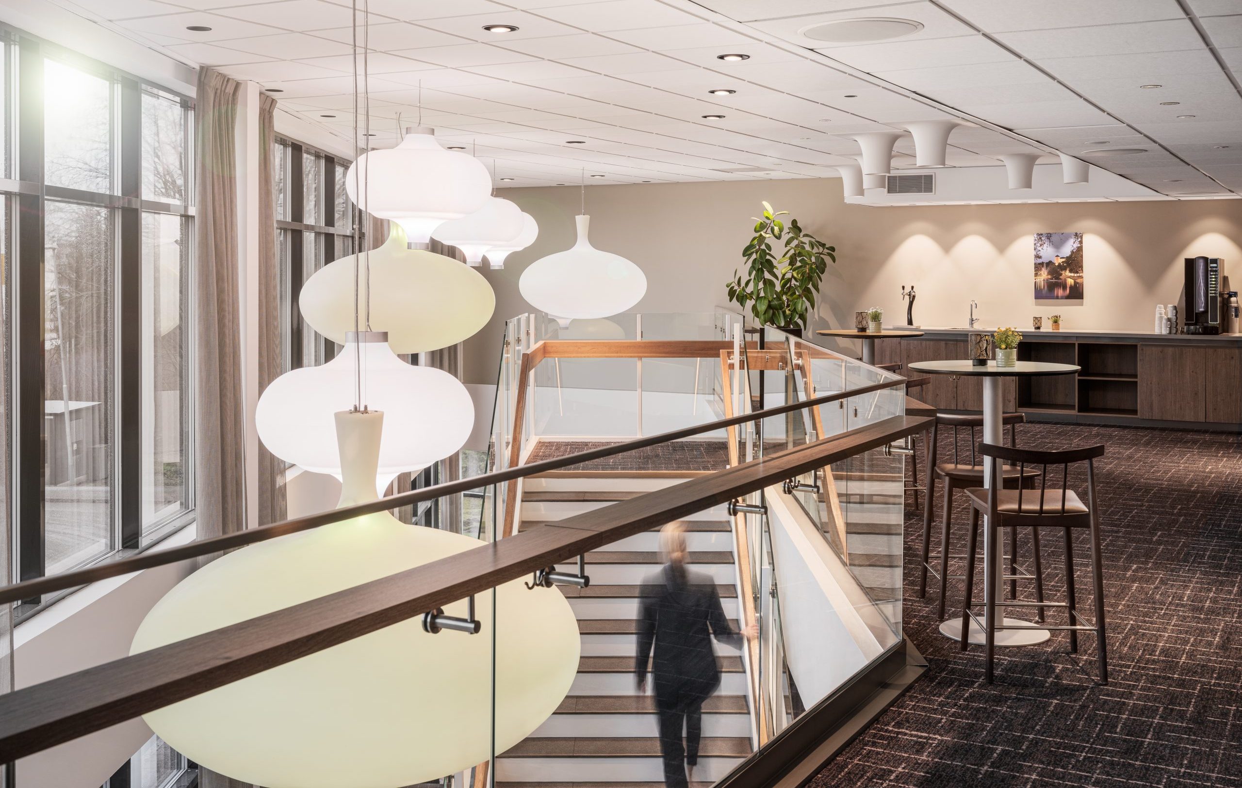 Kvinna som går upp för en trappa inne på Arenahotellet
