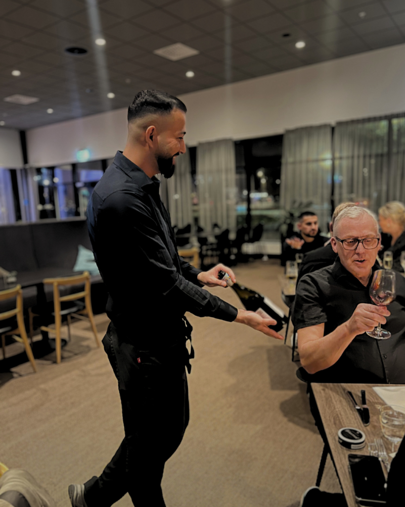 Servitören presenterar en flaska vin för en gäst