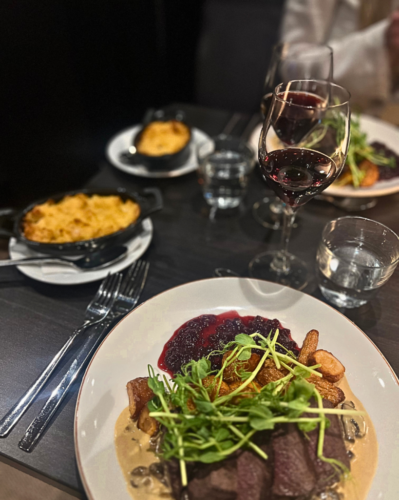 Bord i restaurangen dukat med en maträtt och ett glas vin för två personer.